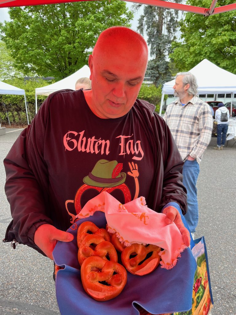 man holding pretzels at farmers market